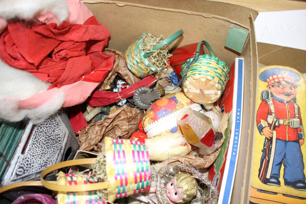 A collection of assorted curios, mostly vintage Christmas decorations but including masks and paper cut-outs